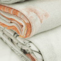 Nahaufnahme: Bedruckter Damen-Schal, helles Gewebe mit orangefarbenem und grauem Muster