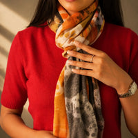 Cashmere-Schal mit abstrakten Farbflecken in Orange, Braun und Grau, weich umgelegt