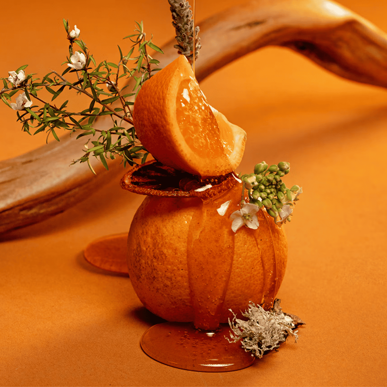 Orangenschale-Dekoration mit Blumen auf orangefarbenem Untergrund