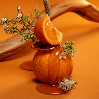 Orangenschale-Dekoration mit Blumen auf orangefarbenem Untergrund