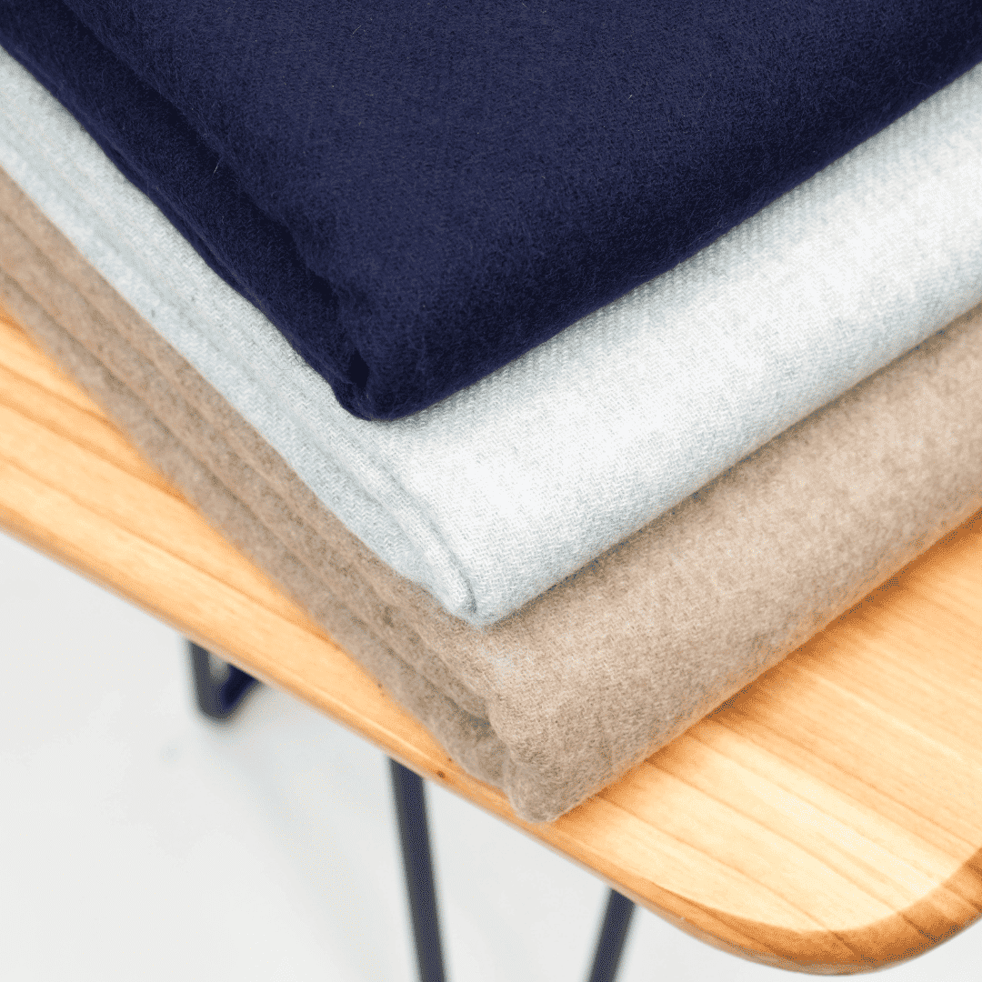 Zusammengelegte Damenstola: dunkles Blau, helles Grau und Beige, Stoffkanten im Detail